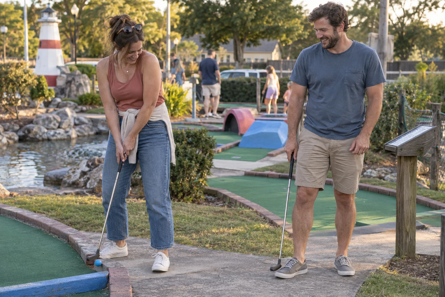 A couple laughing over an imperfect shot during a casual mini-golf date
